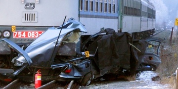 Vlak zcela rozdrtil auto a následně vykolejil. Řidič na místě zemřel.